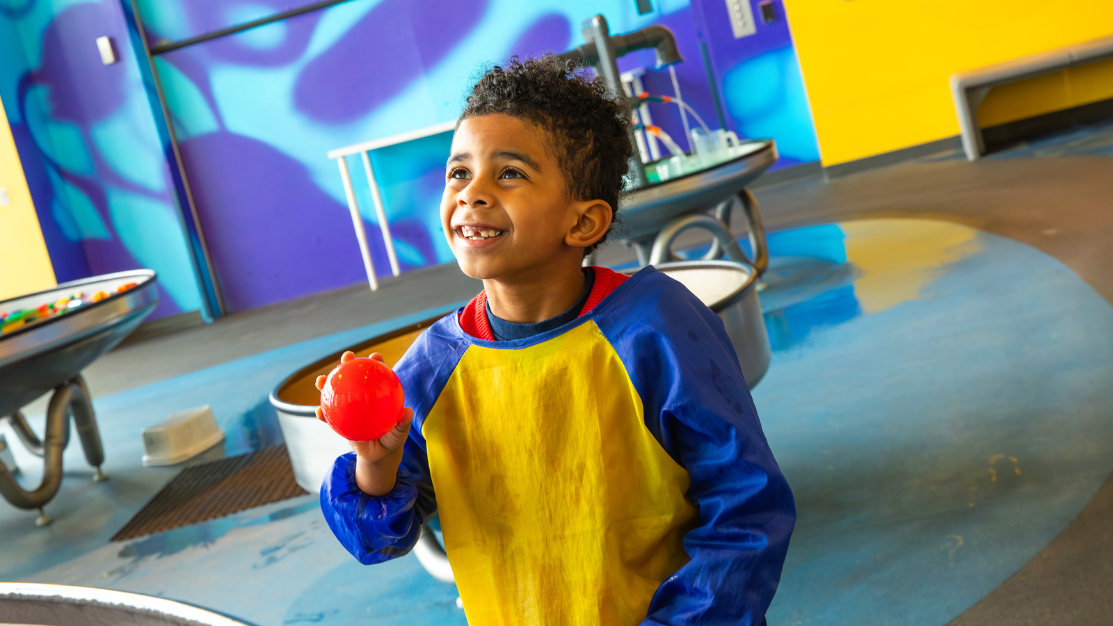 Young boy playing with the water ball at exhibit