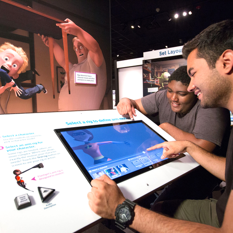Two friends engaging in interactive Elastigirl display