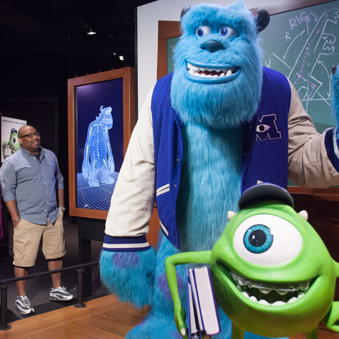 Family looking at Monsters U exhibit within Pixar