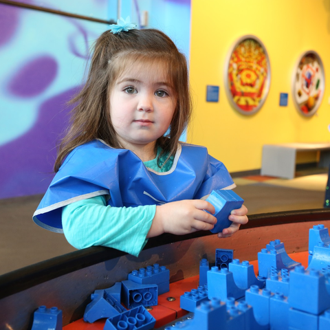 Young girl playing with Legos at the table