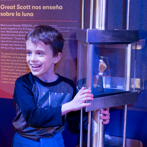 A boy next to part of the Exploring Space exhibit