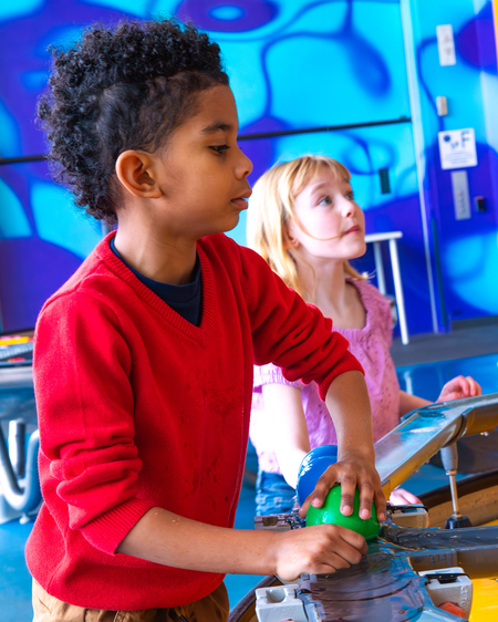 Two children playing at water exhibit