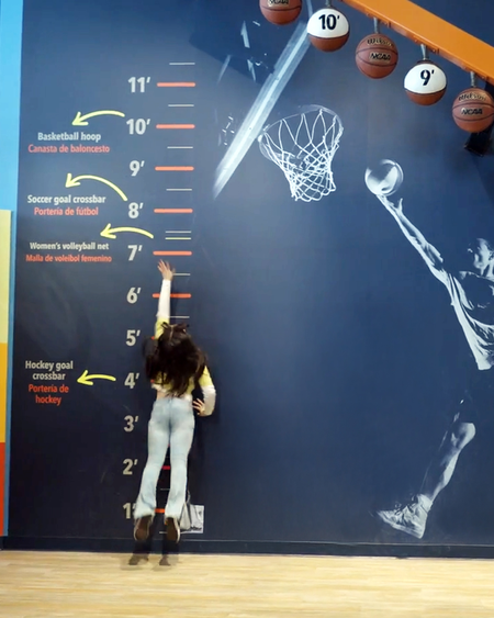 A girl jumping up to see how high she can reach