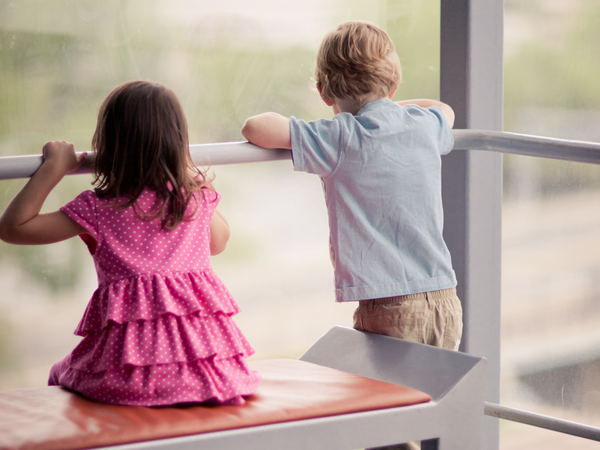 Two children looking out over a balcony
