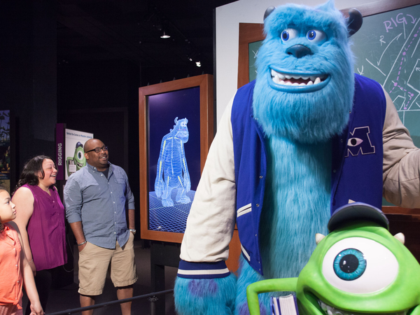 Family looking at Monsters U exhibit within Pixar