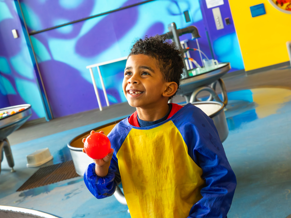 Young boy playing with the water ball at exhibit