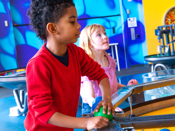 Two children playing at water exhibit