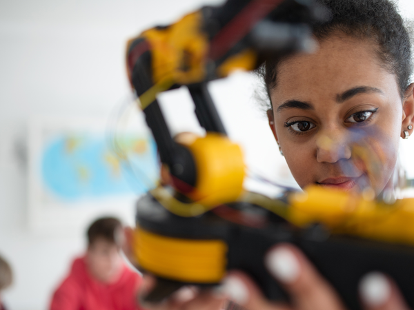 Teen playing with robotics in class