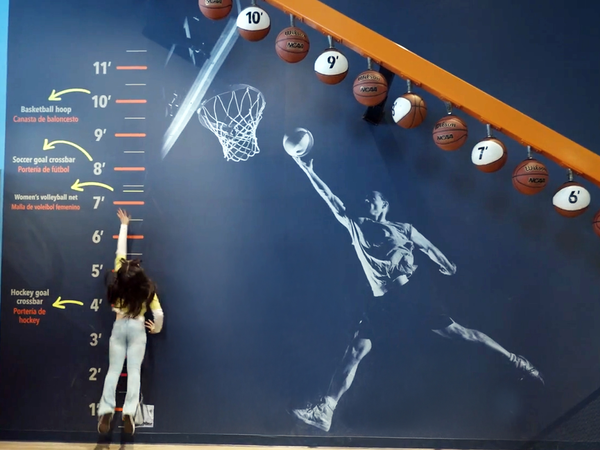 A girl jumping up to see how high she can reach