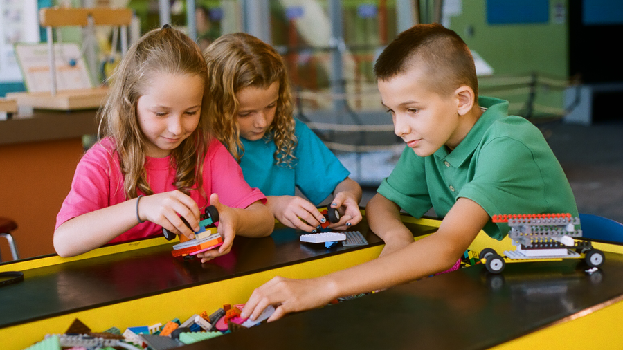 Kids playing at the Lego table in Invention Dimension
