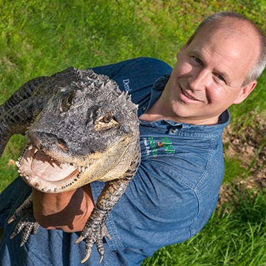 a person holding a large reptile